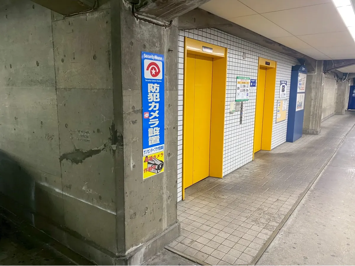 立体駐車場のエレベーター前に掲示された防犯カメラ設置の表示