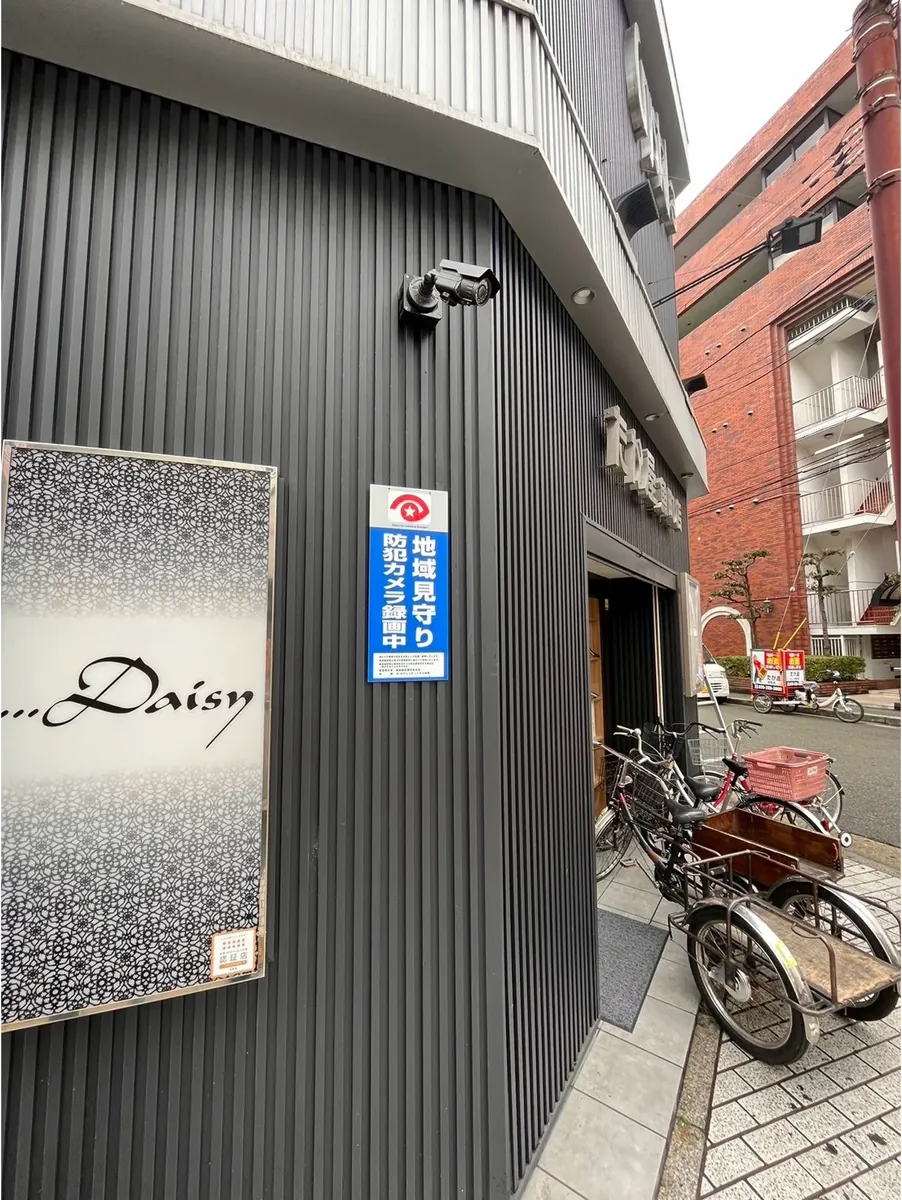 店舗の外壁に設置された防犯カメラと表示板