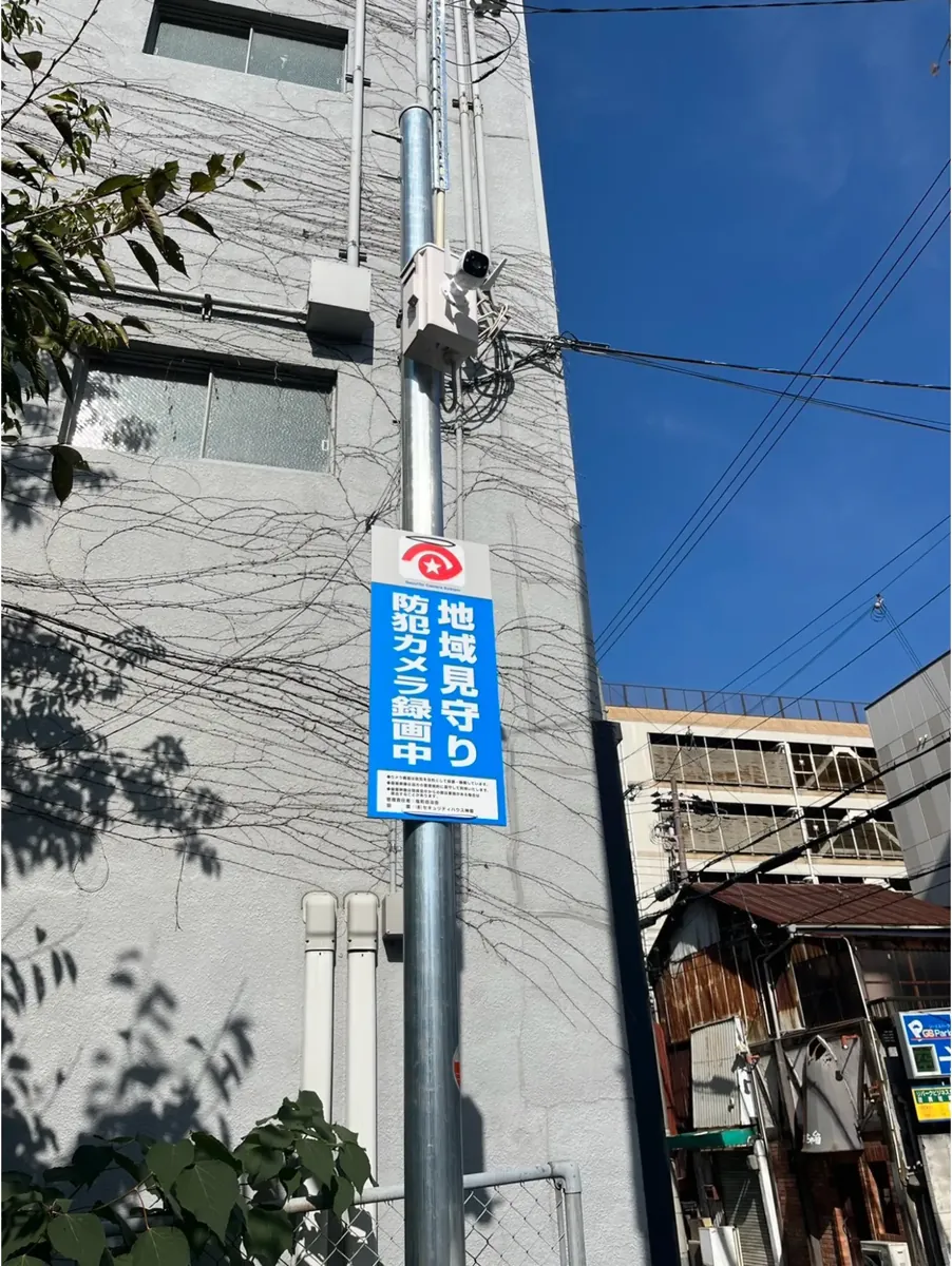 街なかの支柱に設置された地域見守りカメラと録画中の表示板