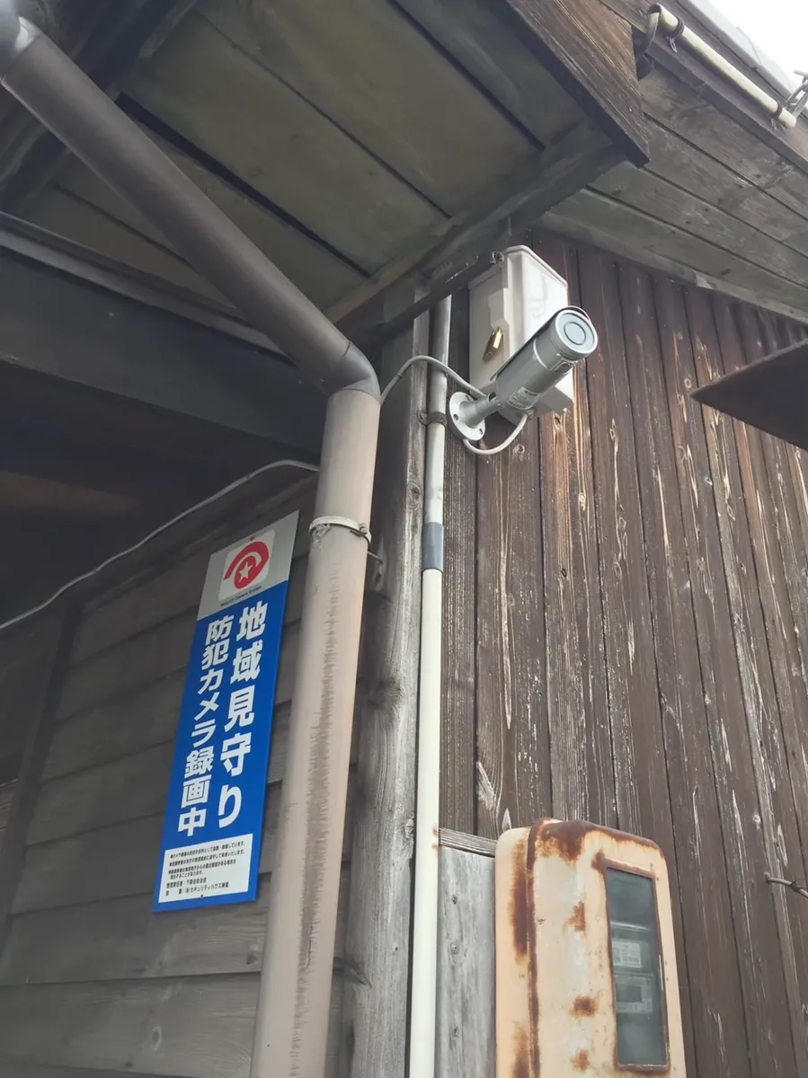 木造建物の軒下に設置された地域見守りカメラ